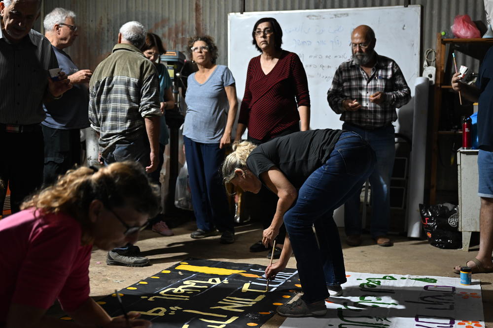 Members of the group, Standing Together, paint signs to hang over bridges. The group's members are Jewish and Palestinian Israelis and the signs are in Hebrew and Arabic, and say: 