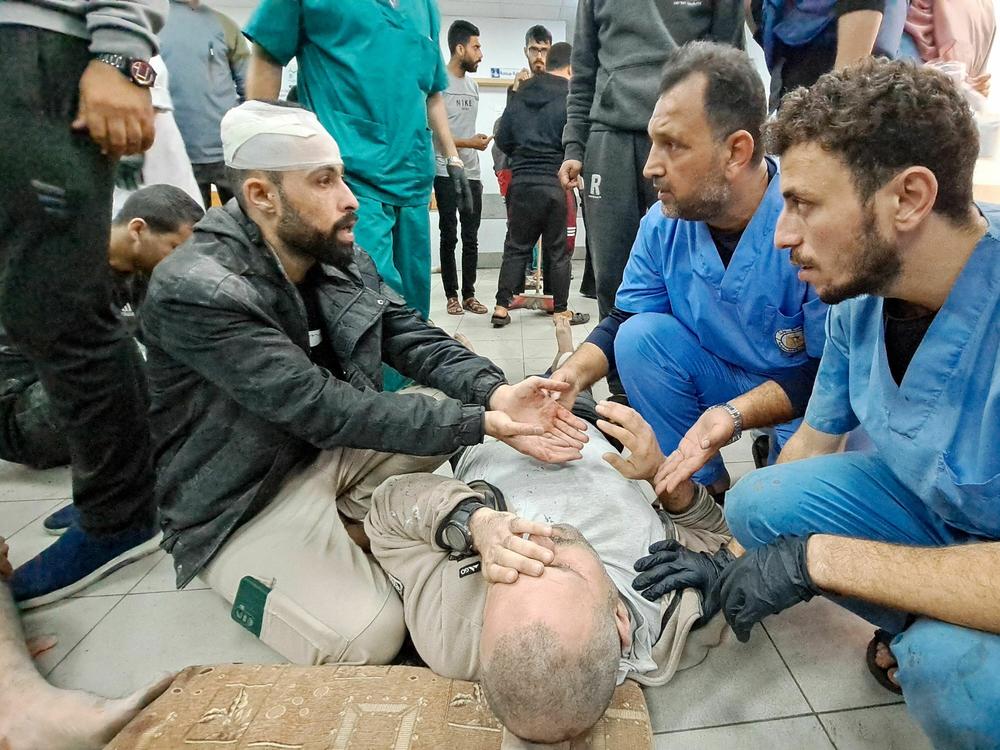 Palestinian medics listen to a man as the wounded are brought to the Kamal Adwan hospital in Beit Lahia in Gaza following Israeli bombardment on Tuesday. The hospital is situated just a few miles south of the Indonesian hospital, which was hit Monday by Israeli shelling, according to Palestinian officials.