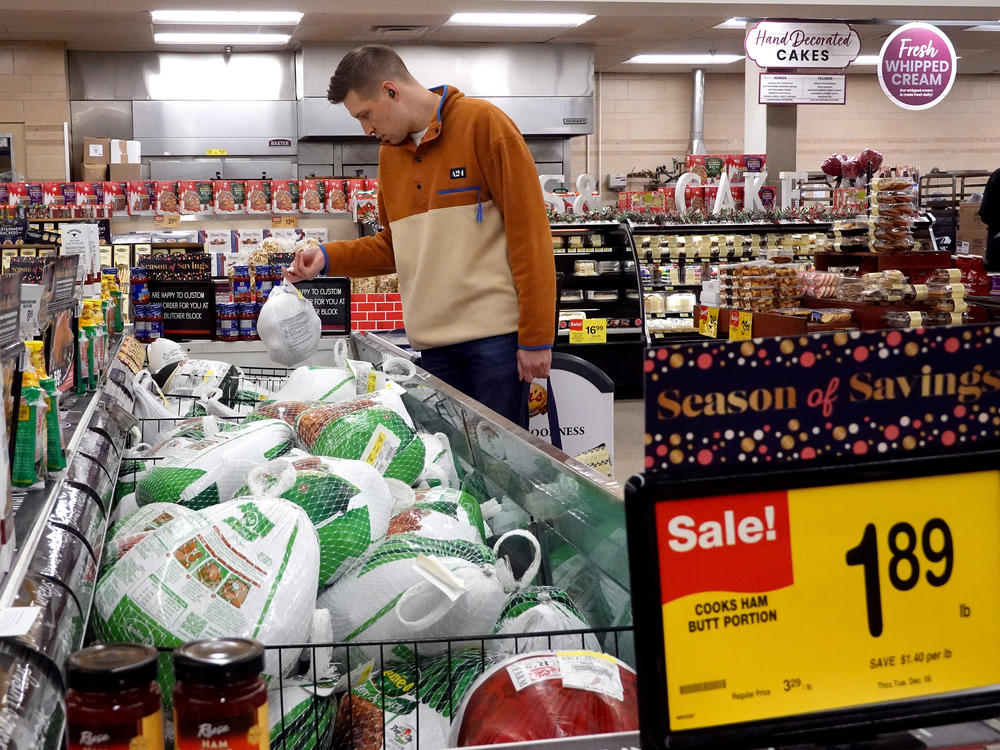A customer in Chicago looks for turkeys offered for sale on Nov. 20, 2023, ahead of the Thanksgiving holiday. Turkey prices have fallen — but the cost of many groceries are still higher.