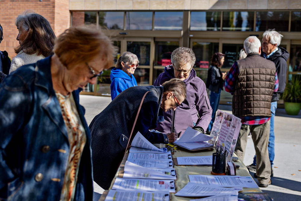 Halli Stone (center right) of Parents Against Bad Books watches as Donna Park signs a petition during a rally last month outside the Idaho Falls Public Library in Idaho. Stone's group was protesting what they see as obscene literature being available at the library.