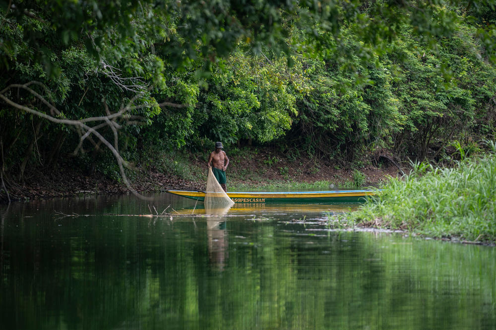 A fisherman throws his net in the Rosario river, contaminated by oil, in Barrancabermeja, Colombia.