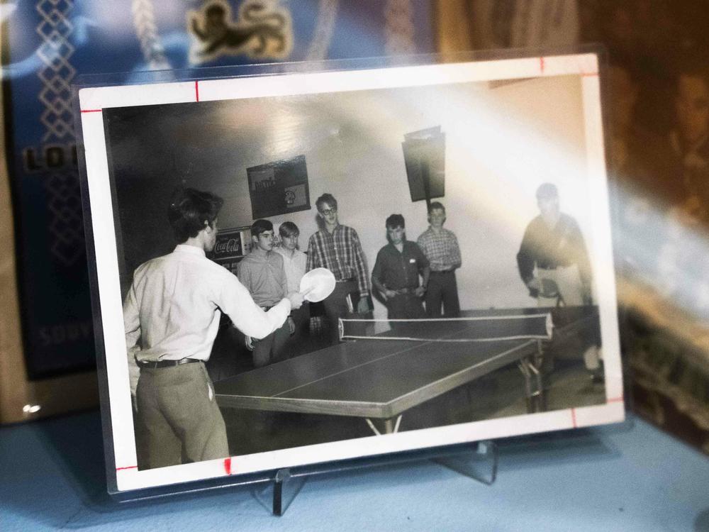 An old high school photo of Will Shortz playing table tennis (L) sits in a glass display case at the Westchester Table Tennis Club.