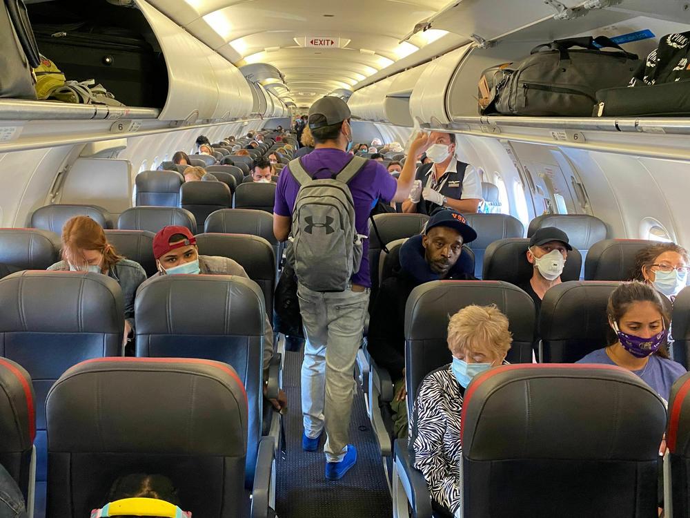 Masking on planes isn't as common as it was in this May 2020 photo, but it is still a good idea, especially if you are on your way to Thanksgiving with older adults or immunocompromised people.