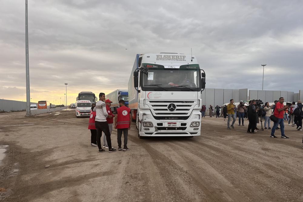 Egyptian Red Crescent volunteers and staff stand near Egypt's Rafah border crossing as trucks carrying humanitarian aid wait to enter the Gaza Strip on Nov. 15.
