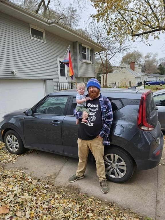 Aarron Schurevich from Omaha, Neb., poses with his son in front of the Kia that he bought after a dealership advertised a discount that seemed impossible to pass up.