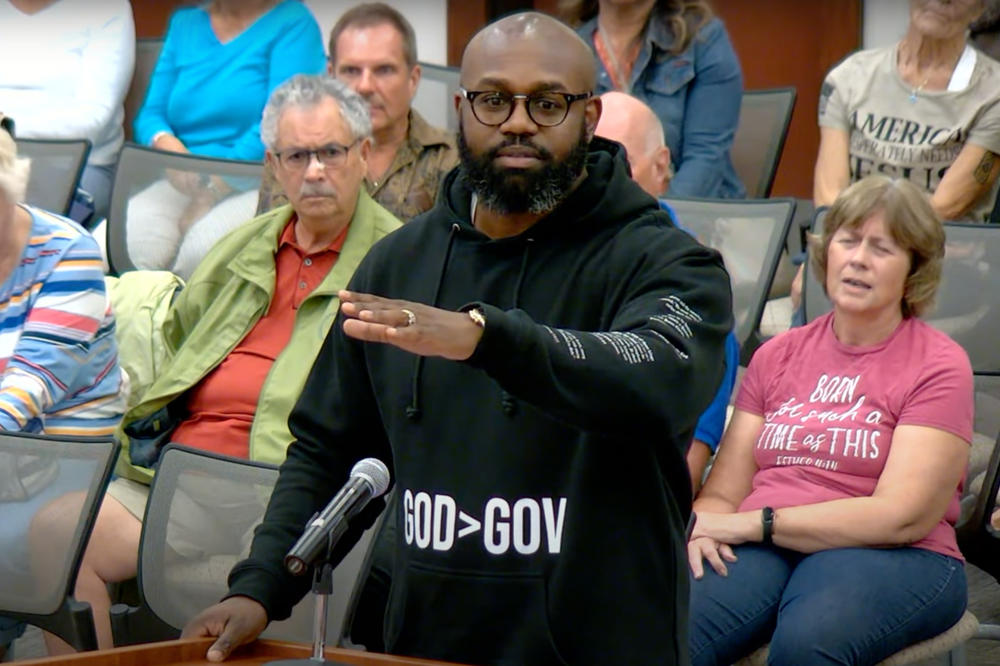 Pastor John K. Amanchukwu speaks at an August school board meeting in Indian River County, Fla. He was just a few words into reading an explicit passage from the book <em>13 Reasons Why </em>when he was cut off by the board chair — triggering the book's automatic removal from the school library.
