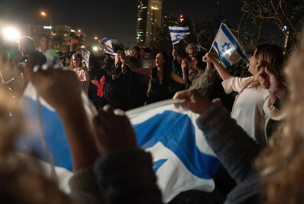 Israelis gather to witness the first batch of hostages released being brought to Schneider Hospital via helicopter.