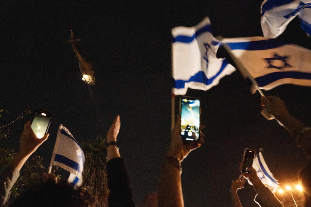 Israelis gather to witness the first batch of hostages released being brought to Schneider Hospital via helicopter.