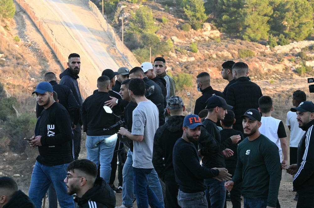 People stand on overlook of Israeli Ofer Prison, where they were showing support waiting for expected release of Palestinian prisoners on Nov. 24, 2023.