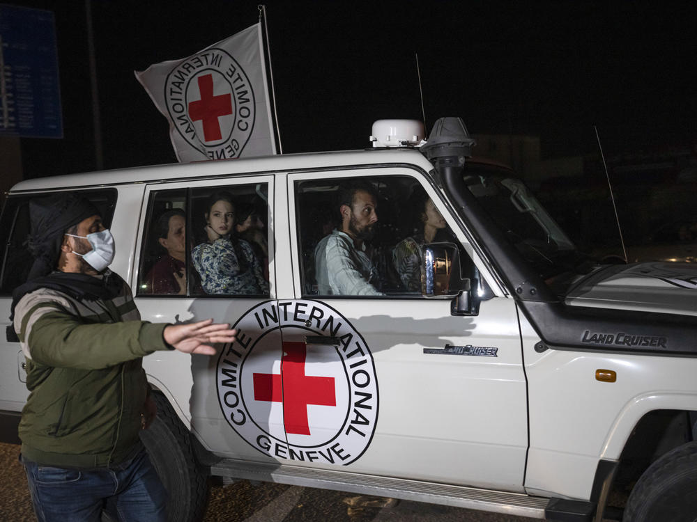 A Red Cross vehicle carrying Israeli hostages drives by at the Gaza Strip crossing into Egypt in Rafah on Saturday, Nov. 25, 2023.