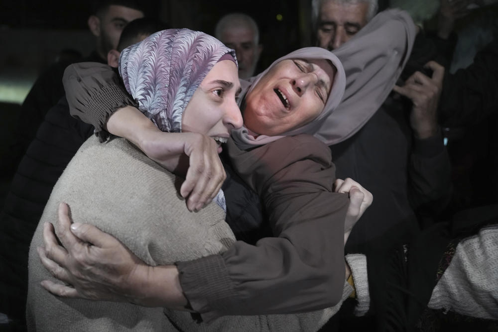 Shuruq Dwayat, left, a Palestinian prisoner released by Israel, is hugged by relatives as she arrives home in the east Jerusalem neighborhood of Sur Bahar, early Nov. 26, 2023.