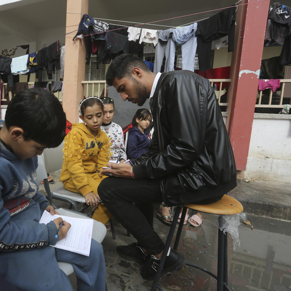 English teacher Tariq Al-Annabi holds a class in a United Nations-run school in Rafah, Gaza Strip, on Sunday — the third day of a temporary cease-fire between Hamas and Israel.