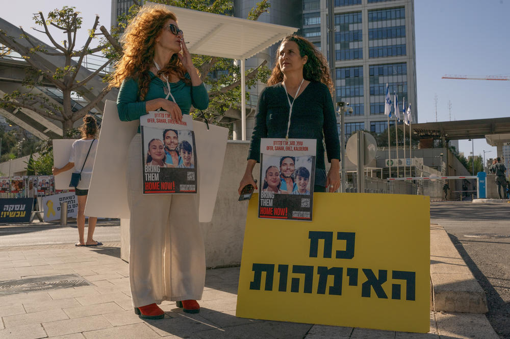 Hadas Calderon, right, who's children and ex husband are being held hostage in Gaza holds a sign that reads the 'power of mothers' outside Israel main army base on Nov. 24, 2023 in Tel Aviv, Israel.