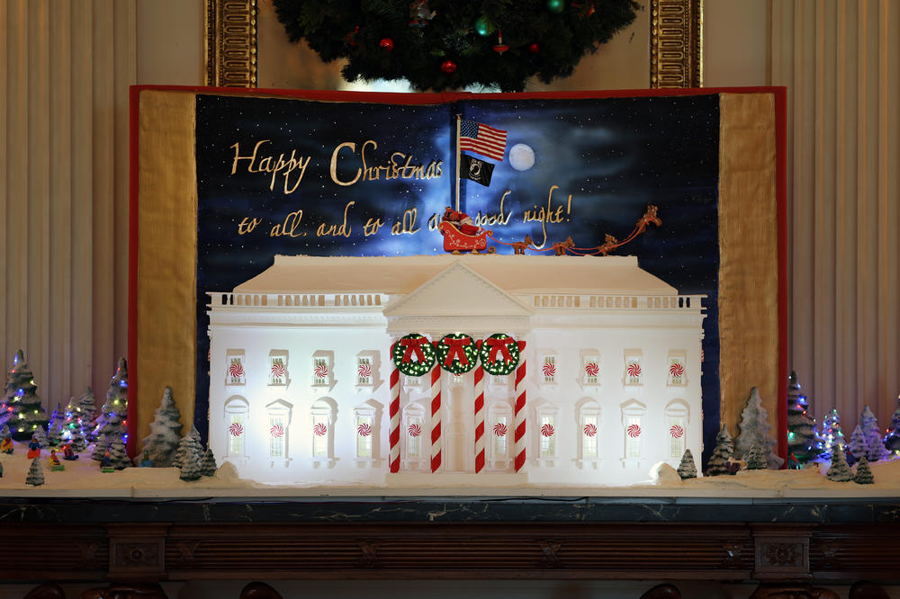 A gingerbread White House is displayed in the State Dining Room.