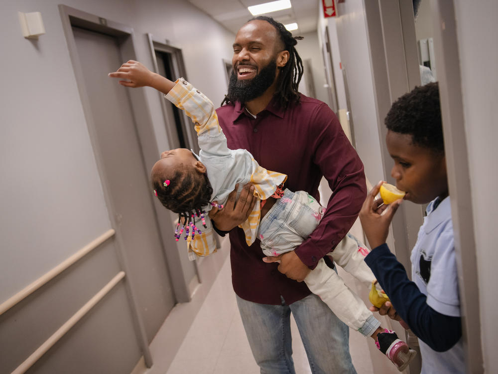 John Bates plays with his daughter Ava, 4, and his son Eli, 10, at Brookdale Family Care Center's clinic in Brooklyn. The Bates family has been connected to the HealthySteps program for years.