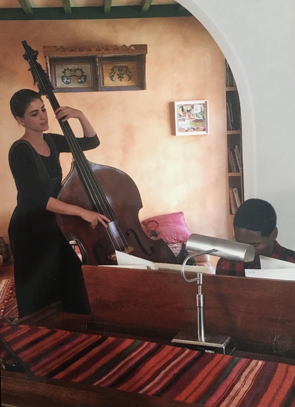 Suleika Jaouad, left, and Jon Batiste, right, first met as teenagers at band camp. In this undated photograph, she plays the double bass while he plays at the piano.