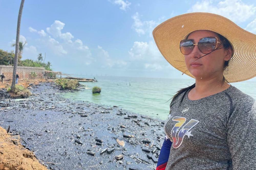 Joseiry Gotera runs a fishing cooperative on Lake Maracaibo, where the PDVSA work brigade was cleaning up the spilled oil that can be seen behind her.