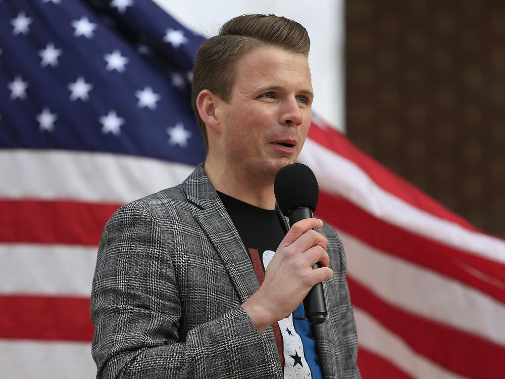 Ryan Fournier, pictured here speaking at a rally in Sugar Hill, Georgia in 2021, has been charged with assaulting a woman with a firearm.