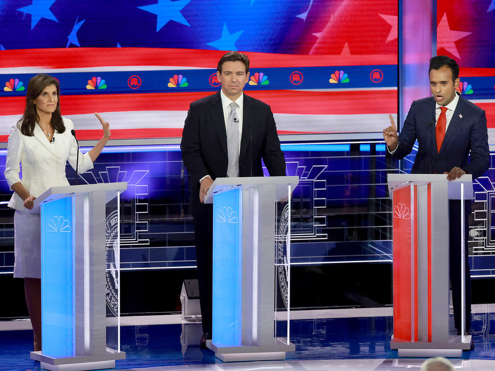 Republican presidential candidate former U.N. Ambassador Nikki Haley puts her hand up to Vivek Ramaswamy while he speaks to her as Florida Gov. Ron DeSantis (C) listens during the NBC News Republican Presidential Primary Debate.