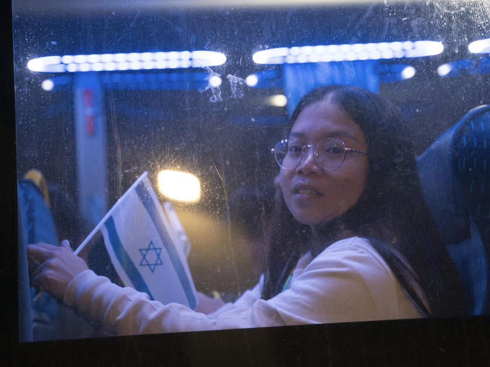 Thai nationals ride a bus as they leave Shamir hospital in Ramla, Israel, on Wednesday, on their way back to Thailand after being released from Hamas' custody.