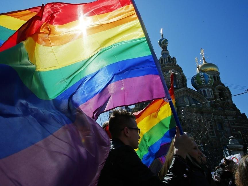 Gay rights activists carry rainbow flags as they march during a May Day rally in 2013 in St. Petersburg, Russia. Russia's Supreme Court on Thursday effectively outlawed LGBTQ+ activism, in the most drastic step against advocates of gay, lesbian and transgender rights in the increasingly conservative country.