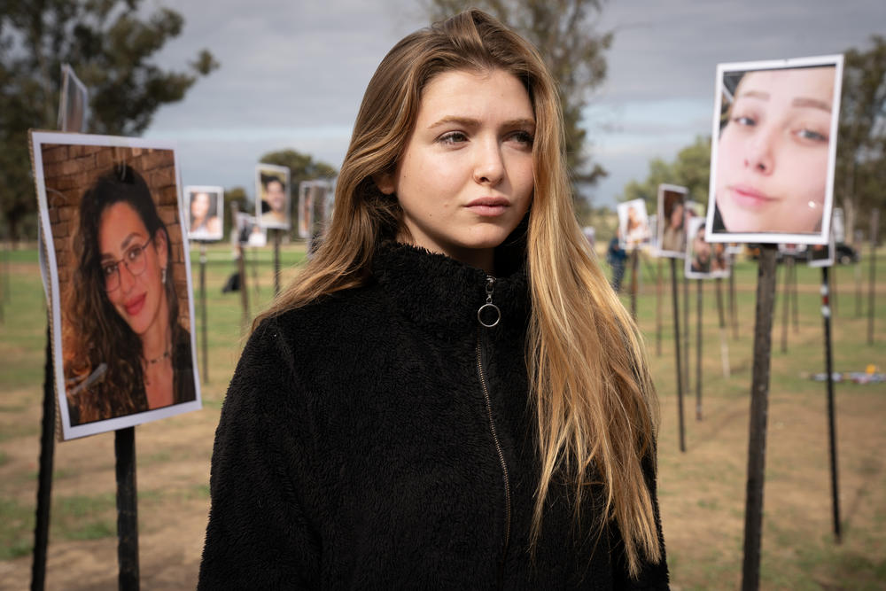 Yarden Guez, 23, looks at photos of people taken captive and killed by Hamas militants at the Nova music festival in southern Israel.