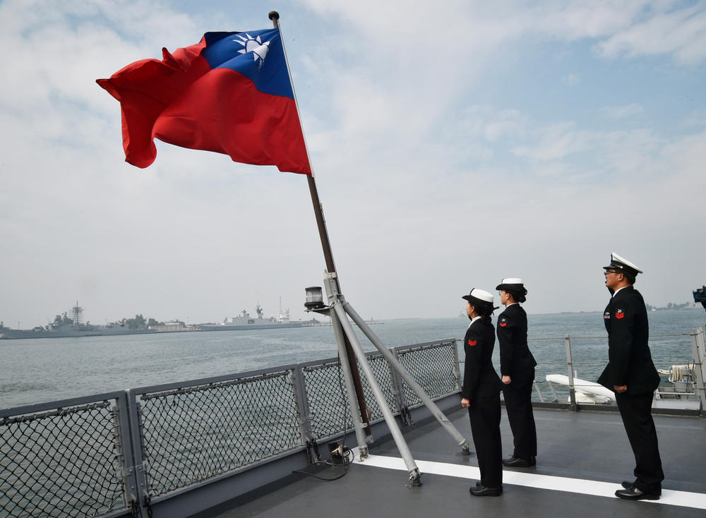 Taiwanese sailors salute the island's flag on the deck of the Panshih supply ship after taking part in annual drills in Jan. 2018.