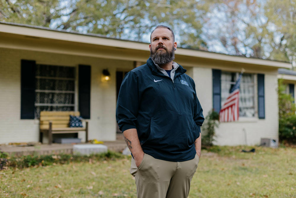 Former Marine Jason Miles stands in front of his home in Clinton, Miss. He lost a sales job during the pandemic and had to take a forbearance.