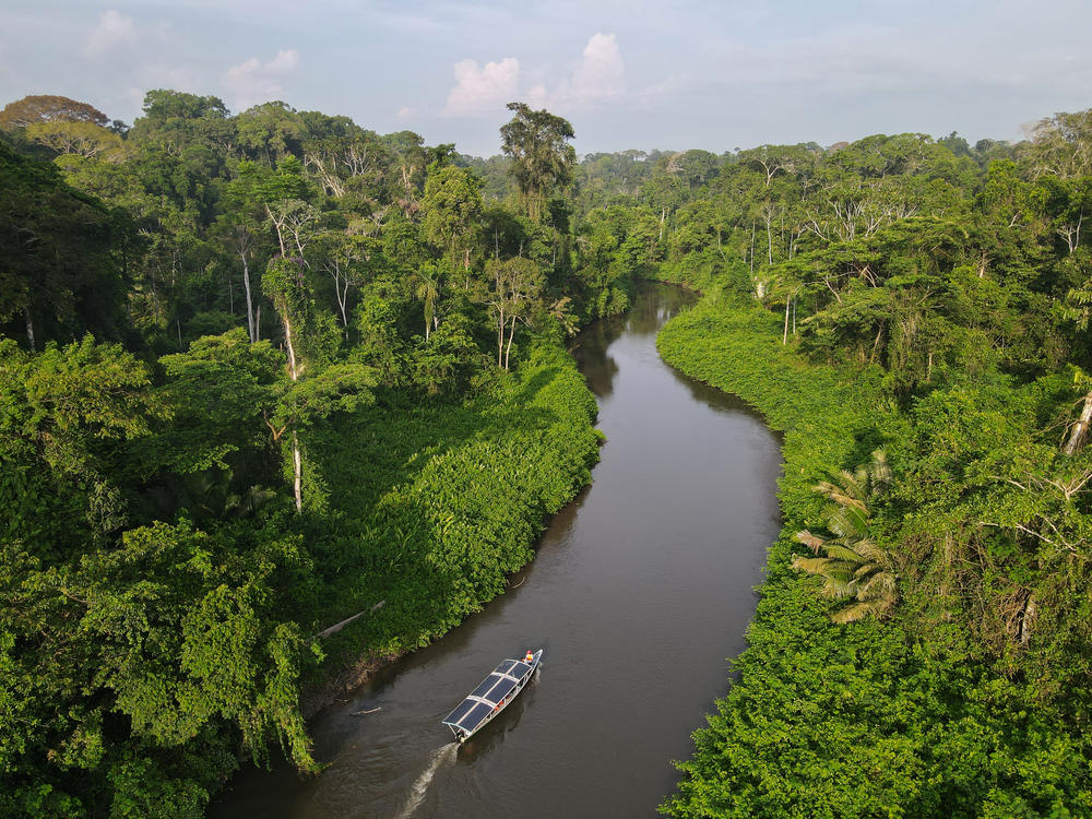 Achuar people ply the Rio Wichimi in a solar canoe. The nonprofit Kara Solar has helped fund a fleet of six sun-powered craft in hopes of benefitting the Indigenous Achuar while reducing pressure to build roads in the rainforest.