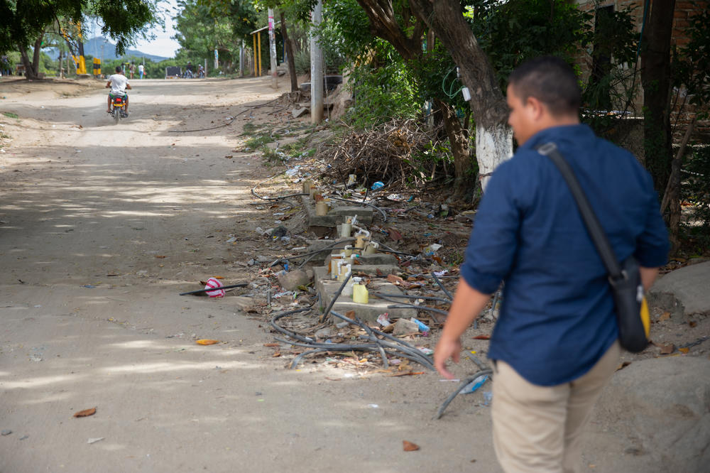 Community leader Carlos Ramos stands by one of the major water connection points in La Paz, where residents hook up their motor pumps to push water from the main pipe through their hoses into their home cisterns<em> </em>hundreds of feet away.