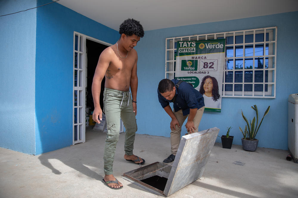 La Paz resident Isaac Campo shows community leader Carlos Ramos that his <em>alberca</em> is almost empty.