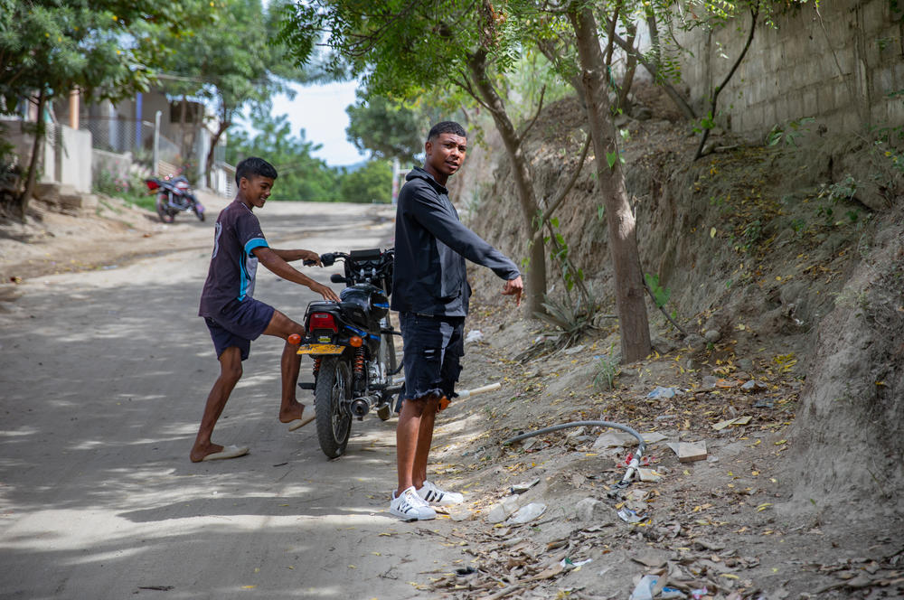 Daniel Palmera (right) points to a pipe in the ground where he and Camilo Castillo tried to set up their motor pump. But on that morning, no more water was available.