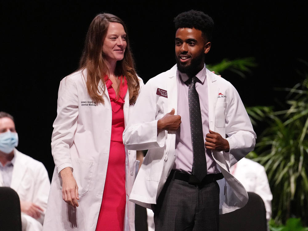 People of color who have a doctor who looks like them report more satisfaction with their health care. Here, Abel Woldu and Dr. Kelsey Angell participate in the University of Minnesota's white coat ceremony in 2022. Half of that incoming class of doctors-in-training are people of color.