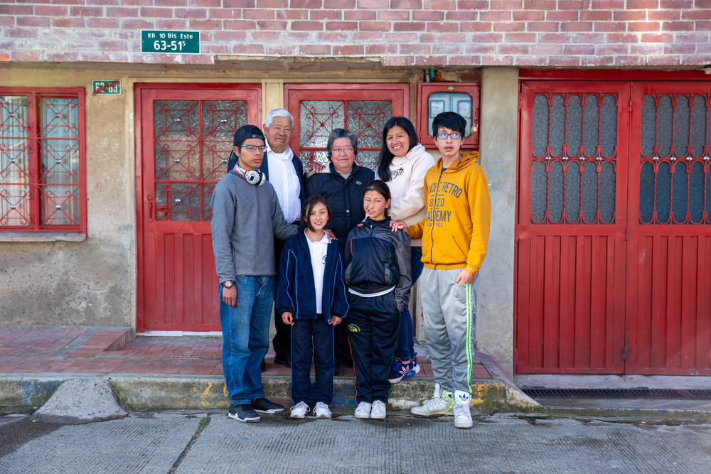 Ruth Infante y su familia posan para un retrato en frente de su casa en San Cristóbal. De izquierda a derecha: William el hijo de Ruth, su sobrina Tania Martínez, su hija Brigitte y su hijo mayor Carlos. Fila de atrás: el padre de Ruth, Neftalí Gómez y su madre Benedicta Infante.