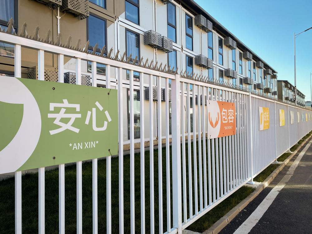 COVID-era slogans attached to fences of the housing complex encourage 