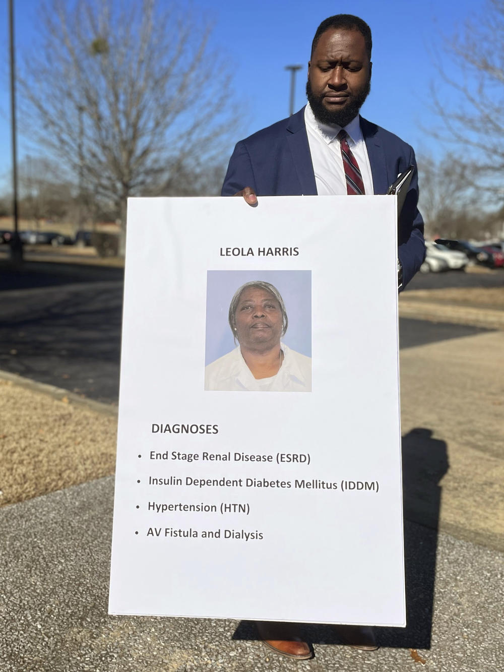 Darrius Culpepper, an attorney with Redemption Earned, stands with a poster showing inmate Leola Harris on Jan. 10, 2023 in Montgomery, Ala. The organization argued Harris, who has now served 20 years of a 35-year sentence for murder, should receive medical parole because of her serious health concerns and clean record in prison.