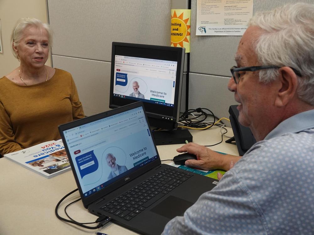 A counselor, right, navigates a client through the Medicare signup process at the Aging and Disability Resource Center of Broward County in Sunrise, Florida. Medicare open enrollment season ends Dec. 7.