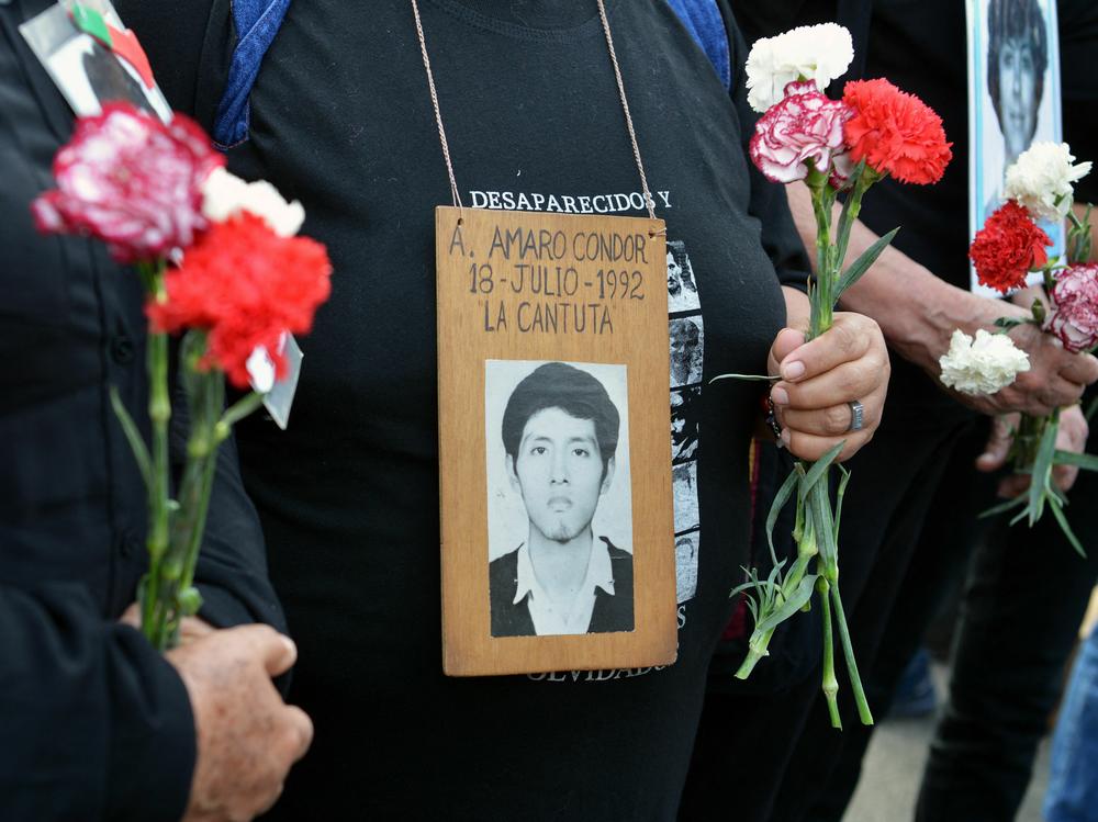 Demonstrators hold carnations and bear portraits of the victims of repression during the rule of Alberto Fujimori (1990-200), as they march in Lima against the presidential pardon he was granted on Jan. 30, 2018.