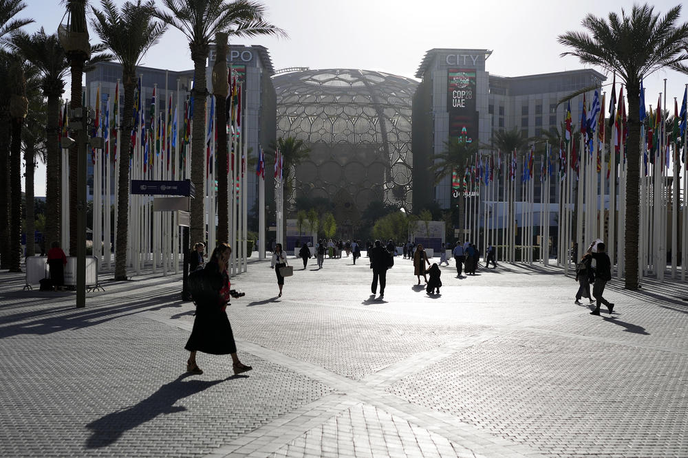 People walk through the venue at the COP28 U.N. Climate Summit near the Al Wasl Dome.