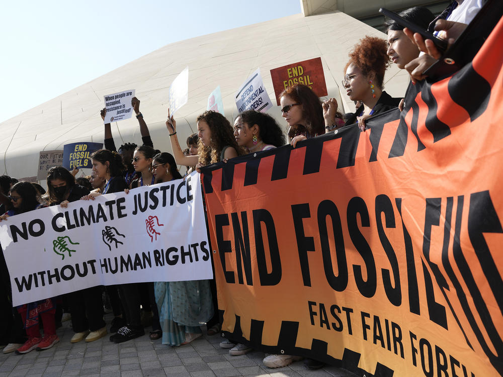 Demonstrators hold a sign reading 