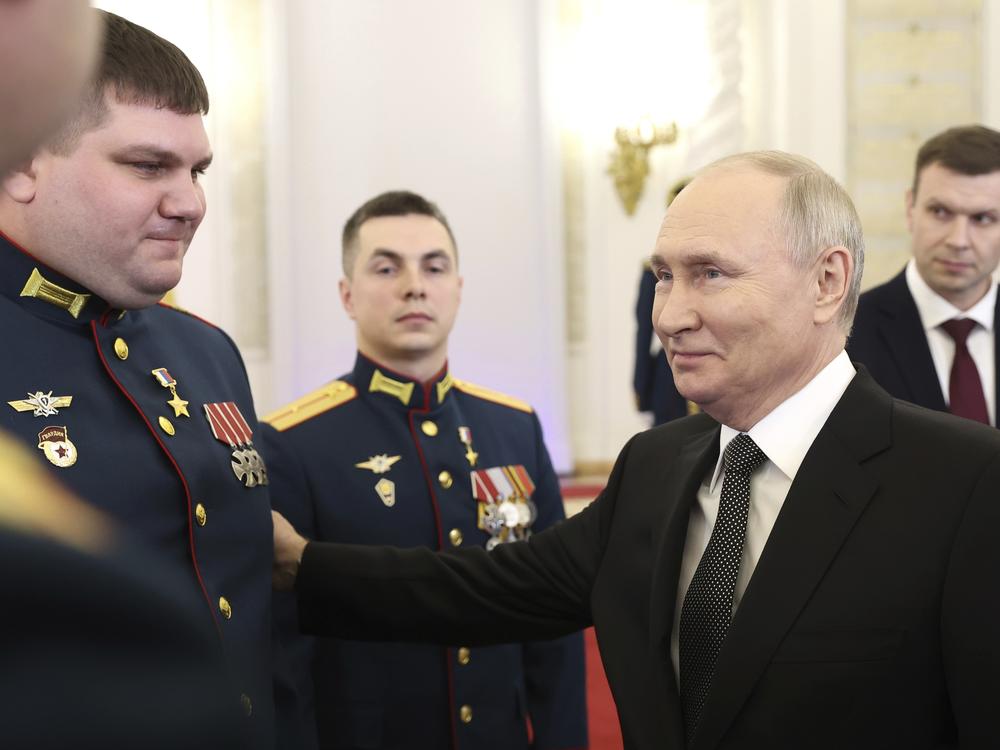Russian President Vladimir Putin talks with awarded Russian servicemen at the Grand Kremlin Palace in Moscow on Friday.