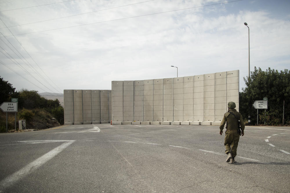 A soldier walks near a temporary wall that was placed near the Israeli border with Lebanon on Oct. 29, in Kiryat Shmona, Israel.