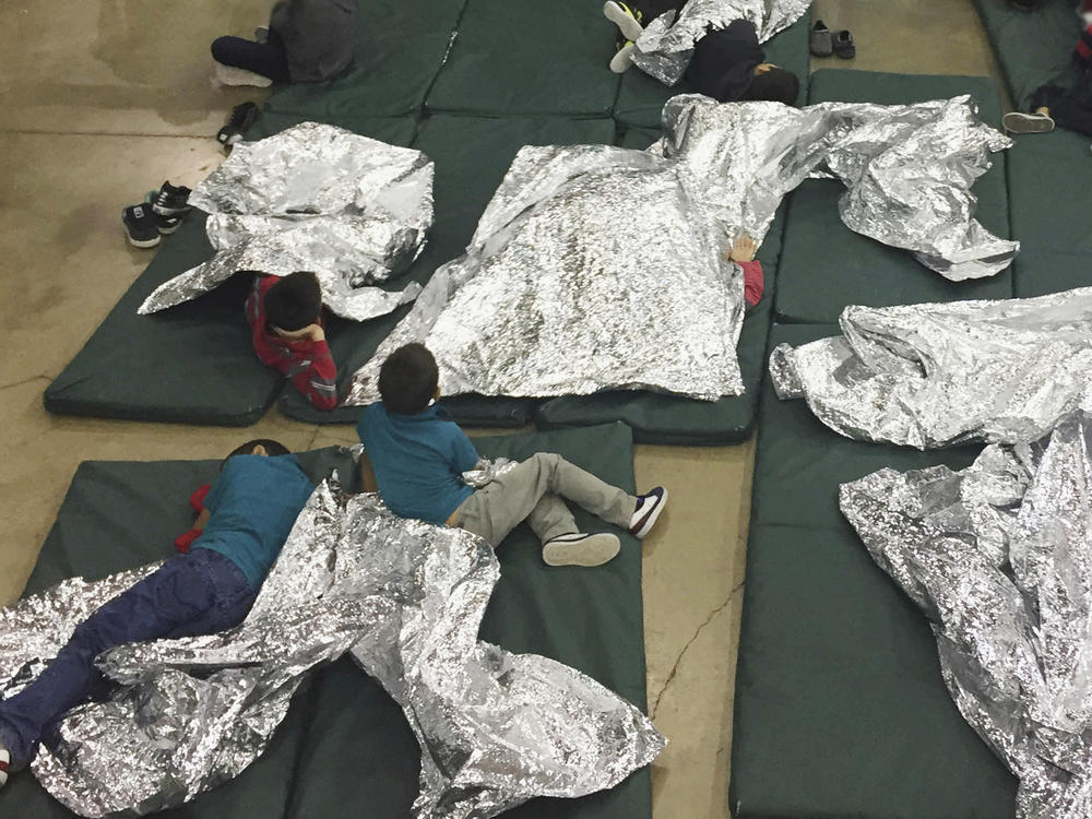 In this photo provided by U.S. Customs and Border Protection, people taken into custody related to cases of illegal entry into the U.S. waited in one of the cages at a facility in McAllen, Texas, in June 2018.