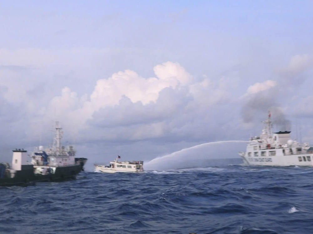 In this photo provided by the Philippine Coast Guard, a Chinese coast guard ship uses water cannons on Philippine navy-operated supply boat M/L Kalayaan as it approaches Second Thomas Shoal, locally known as Ayungin Shoal, in the disputed South China Sea on Sunday, Dec. 10, 2023.