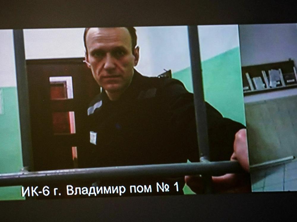 A screen shows jailed Kremlin critic Alexei Navalny as he arrives to listen to a hearing on an appeal lodged against a court decision to jail him for 19 years in a maximum security prison on extremism-linked charges, at a court in Moscow on Sept. 26.