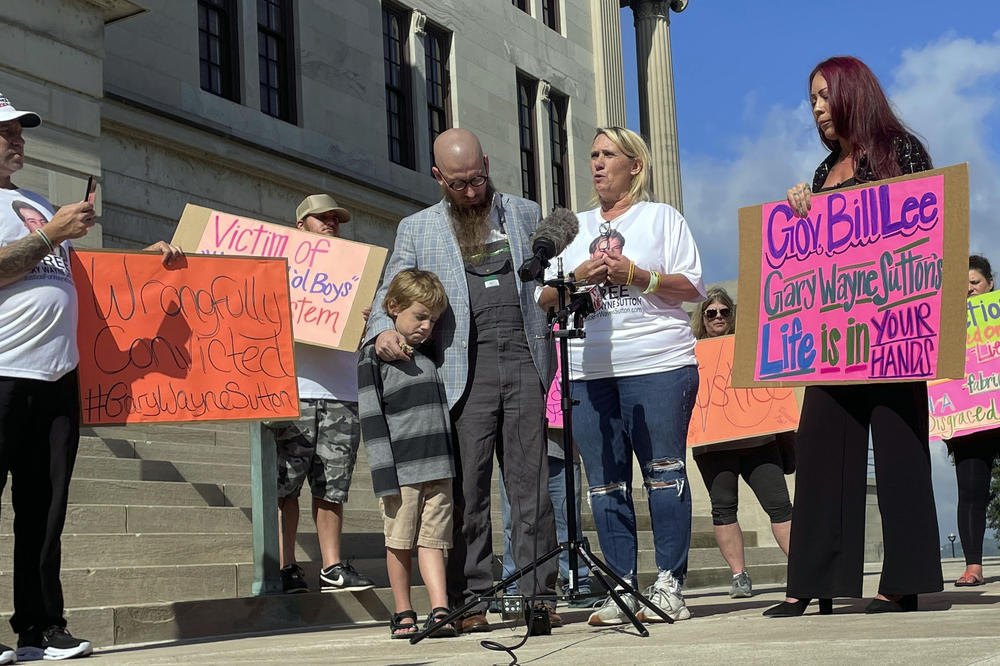 Carolyn Miller (center right) speaks at a news conference called by friends and family of Tennessee death row inmate Gary Sutton on Oct. 6, outside the Tennessee State Capitol in Nashville. Rev. Jeff Hood stands next to Miller while hugging his son.
