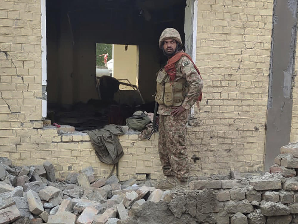 An army soldier examines damages on the site of a bombing at a police station on the outskirts of Dera Ismail Khan, Pakistan, Tuesday, Dec. 12, 2023.