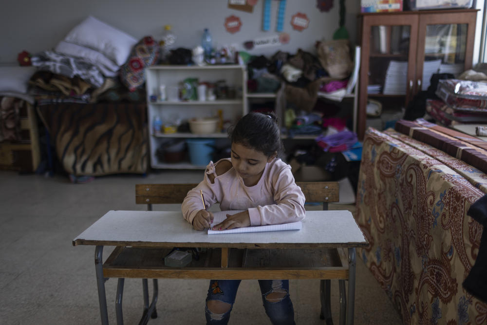 A 7-year-old Lebanese internally displaced person from al-Jibbayn, Lebanon, draws inside a school that is being used as a shelter.