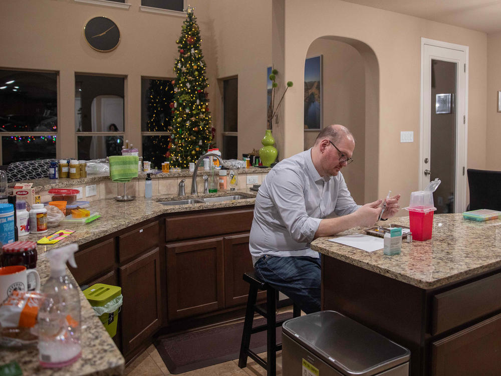 Paul Zucknick prepares a syringe to give his wife, Diana, an IVF injection.