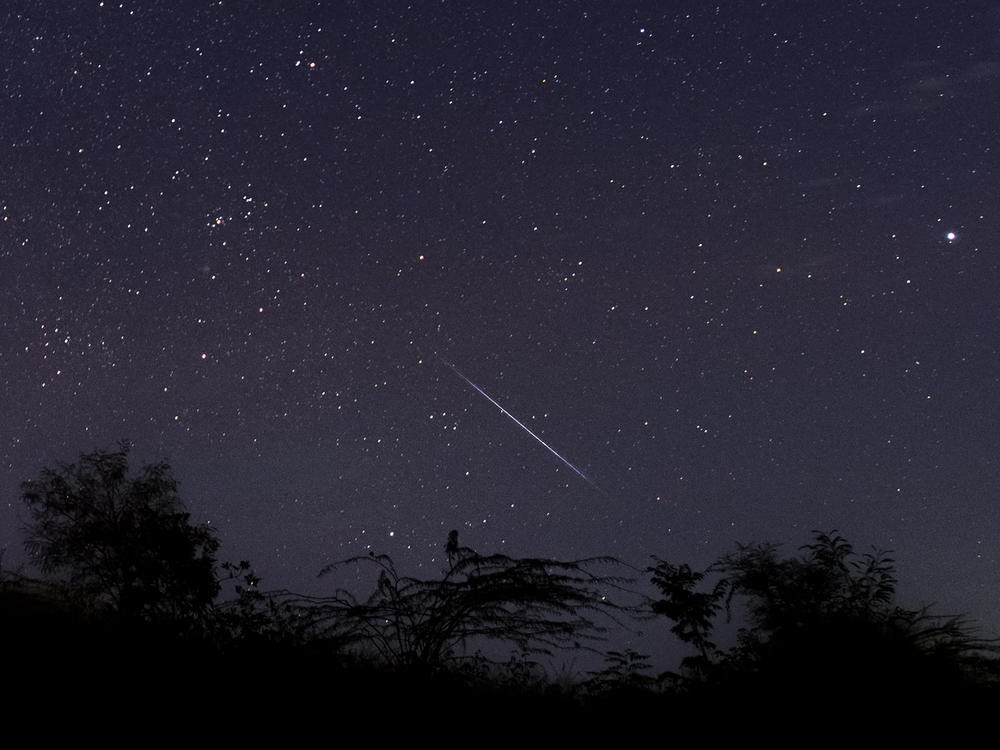 This photo taken late December 14, 2018 with a long time exposure shows a meteor streaking through the night sky over Myanmar during the Geminid meteor shower seen from Wundwin township near Mandalay city.